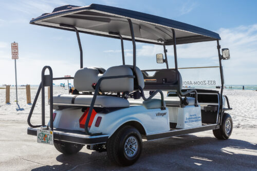 A golf cart with seats on the back of it.
