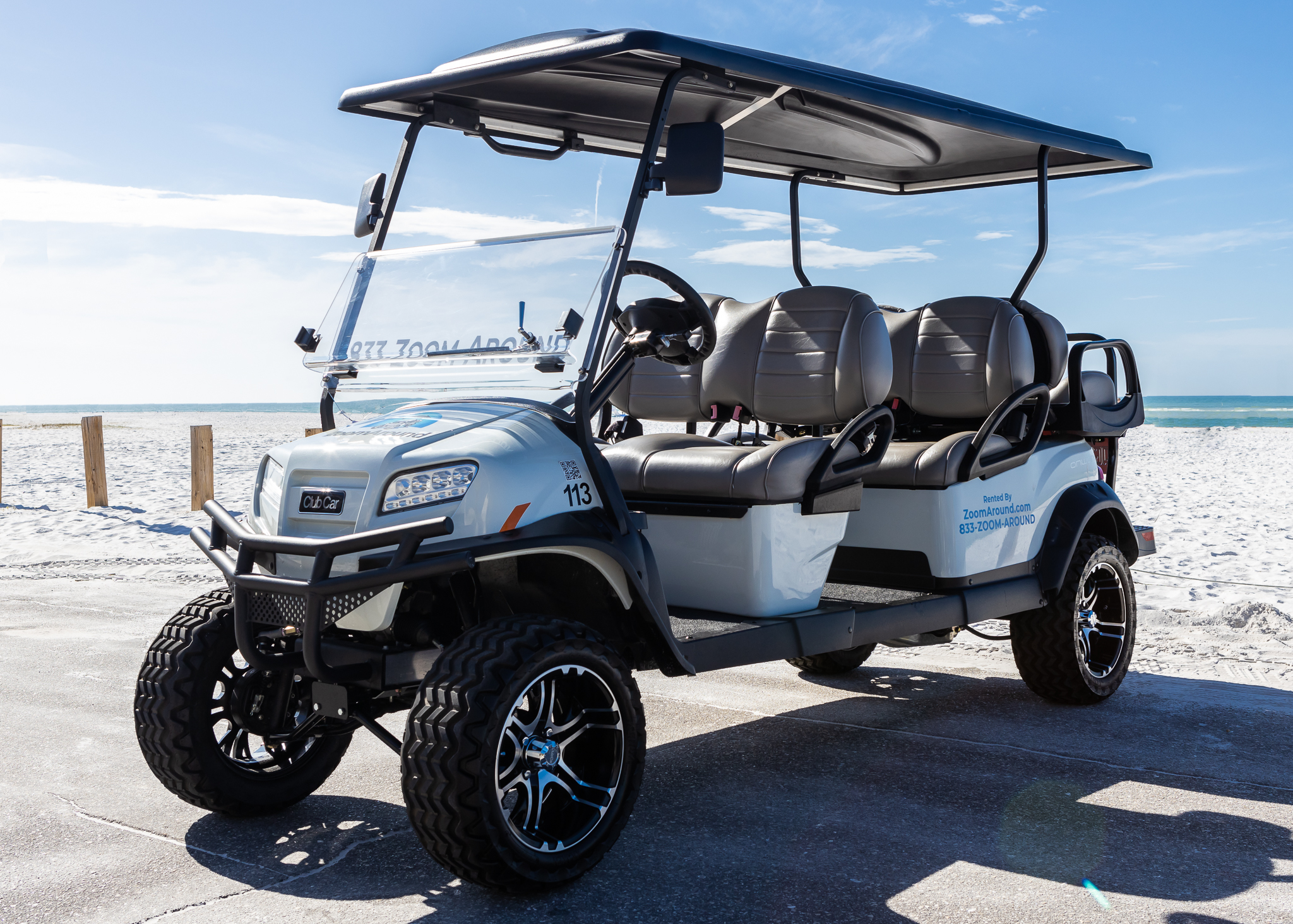 A golf cart with six seats and a large roof.